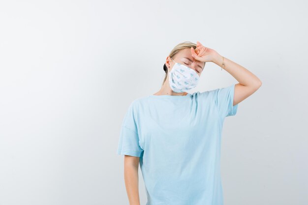 Jeune femme en t-shirt bleu avec un masque médical