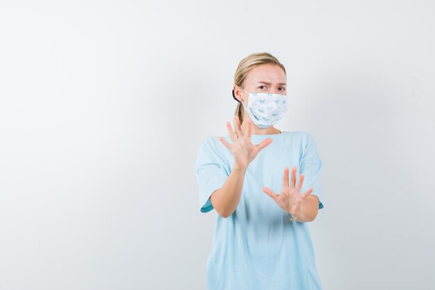 Jeune femme en t-shirt bleu avec un masque médical