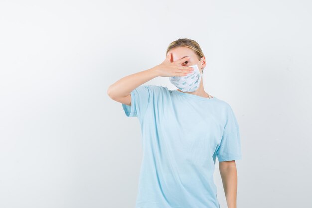 Jeune femme en t-shirt bleu avec un masque médical