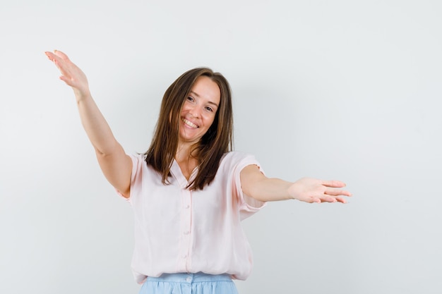 Photo gratuite jeune femme en t-shirt, bras ouvrant jupe pour câlin et à la vue amicale, de face.