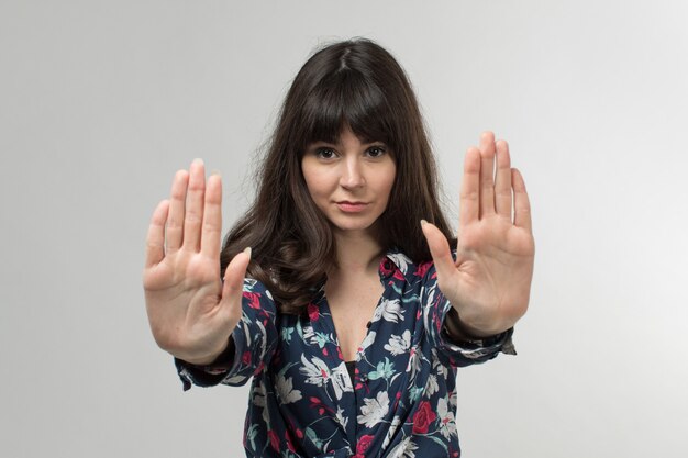 Photo gratuite jeune femme en t-shirt conçu avertissement avec les mains aux cheveux longs sur blanc