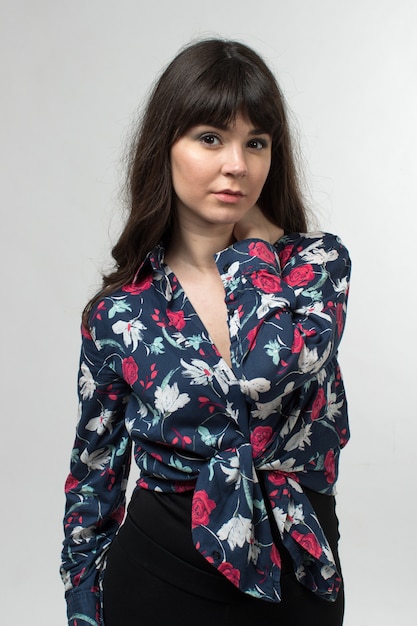 jeune femme en t-shirt conçu posant avec des cheveux longs sur blanc