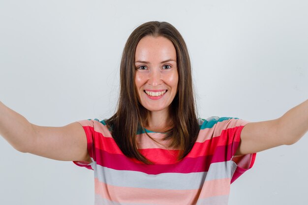 Jeune femme en t-shirt à la joyeuse vue de face.