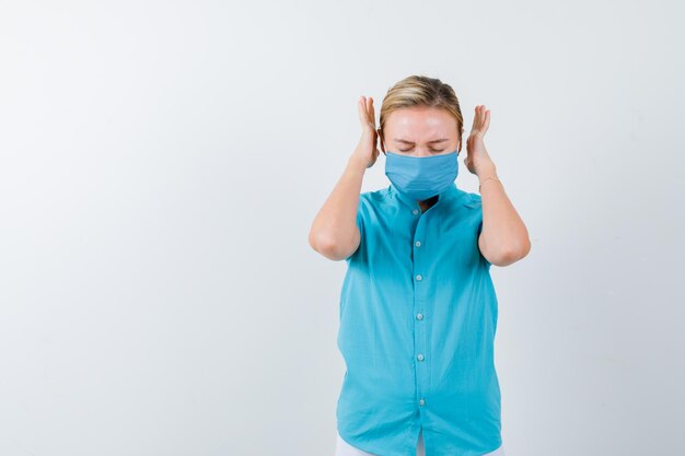 Jeune femme en t-shirt, masque gardant les mains de manière agressive et semblant ennuyée