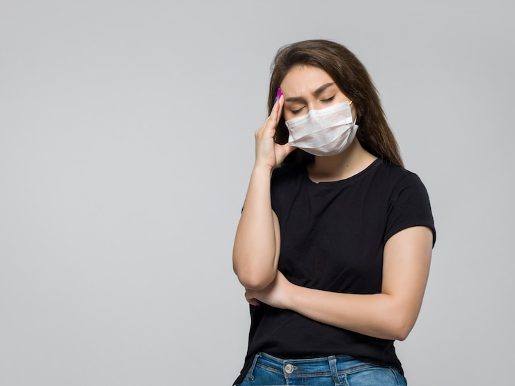 Photo gratuit jeune femme en t-shirt noir et masque médical stérile blanc ayant de forts maux de tête