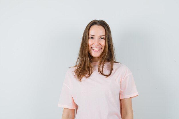 Jeune femme en t-shirt rose et à la joie. vue de face.