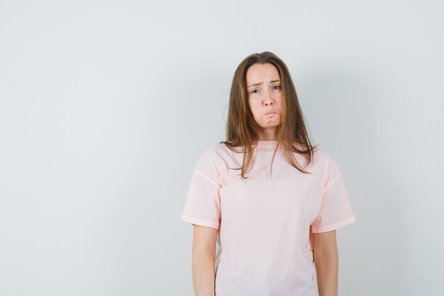 Jeune femme en t-shirt rose et à la vue offensée, avant.