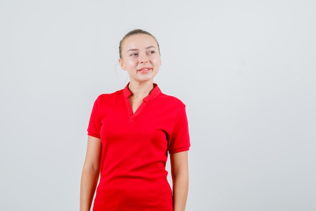Jeune femme en t-shirt rouge à la recherche de suite et à l'optimiste