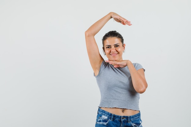 Jeune femme en t-shirt, short montrant le geste de la danse traditionnelle et à la fringante