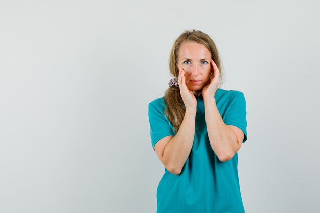 Jeune femme en t-shirt touchant la peau de son visage et à l'élégante