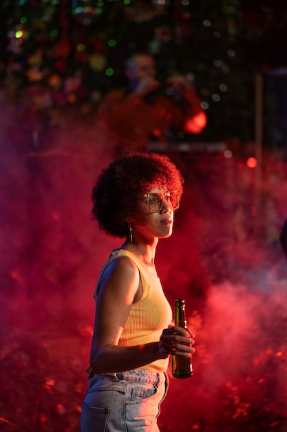 Une jeune femme de taille moyenne danse à une fête techno.