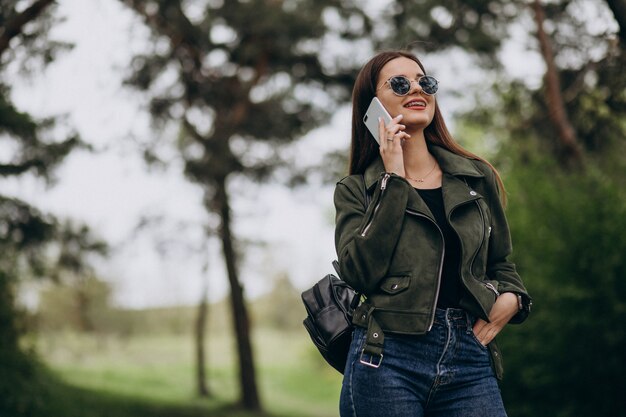 Jeune femme, talkimng, téléphone, dans parc