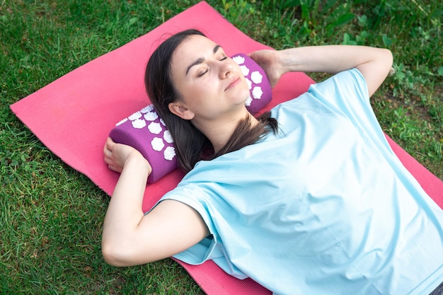 Une jeune femme sur un tapis d'acupression massage d'acupuncture