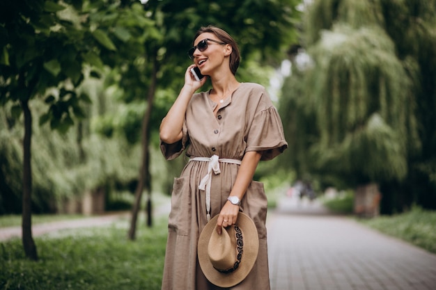 Jeune femme avec un téléphone portable dans le parc