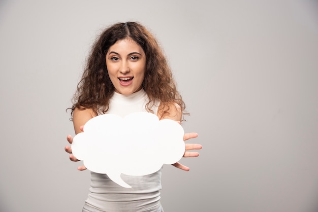 Photo gratuite jeune femme tenant une affiche de discours blanc vide vide. photo de haute qualité