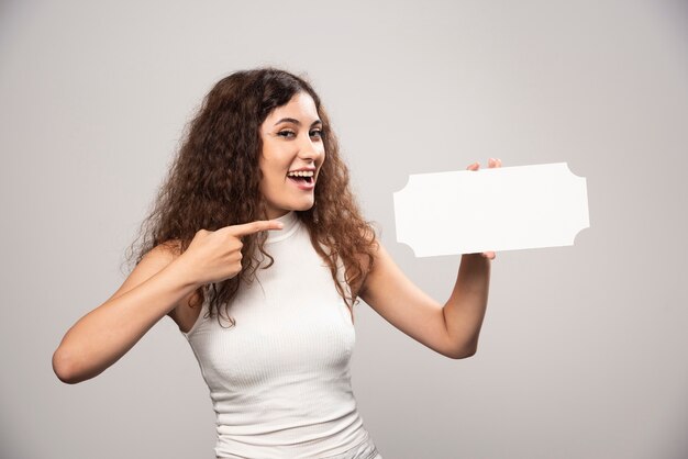 Jeune femme tenant une affiche de discours blanc vide vide. Photo de haute qualité