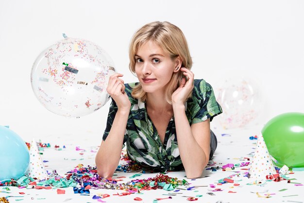 Jeune femme tenant un ballon et regardant un photographe