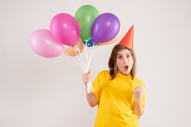 jeune femme tenant des ballons colorés sur blanc