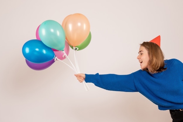 jeune femme tenant des ballons colorés sur blanc