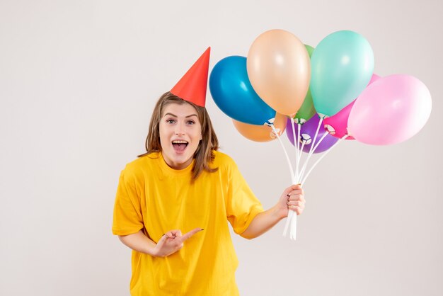 jeune femme tenant des ballons colorés sur blanc