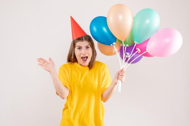 jeune femme tenant des ballons colorés sur blanc