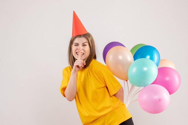 jeune femme tenant des ballons colorés sur blanc