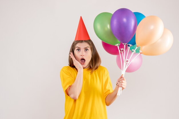 jeune femme tenant des ballons colorés sur blanc