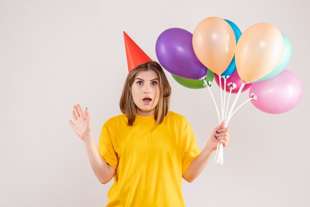jeune femme tenant des ballons colorés sur blanc