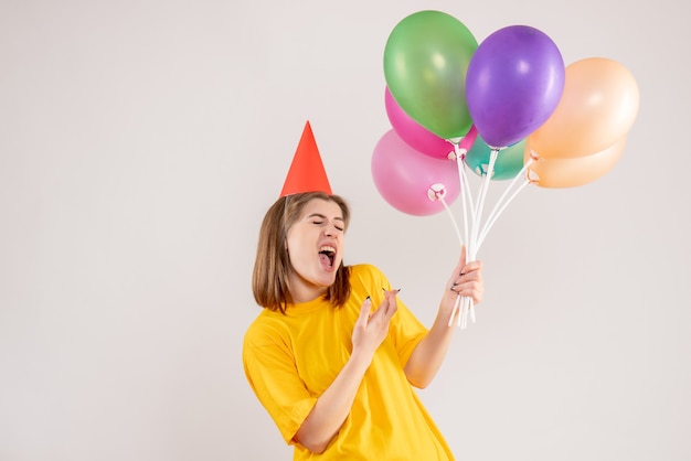 jeune femme tenant des ballons colorés sur blanc