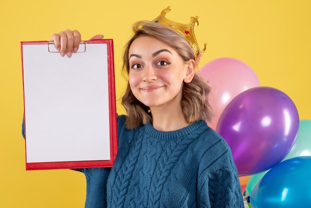 jeune femme tenant des ballons colorés et note sur jaune