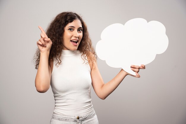 Jeune femme tenant une bulle de dialogue blanc vide vide. Photo de haute qualité