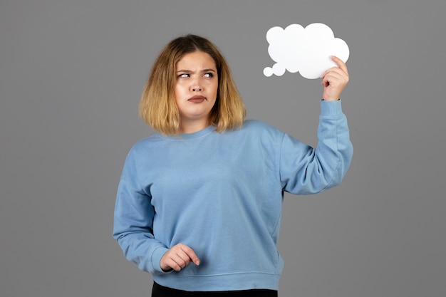 Jeune femme tenant une bulle de pensée