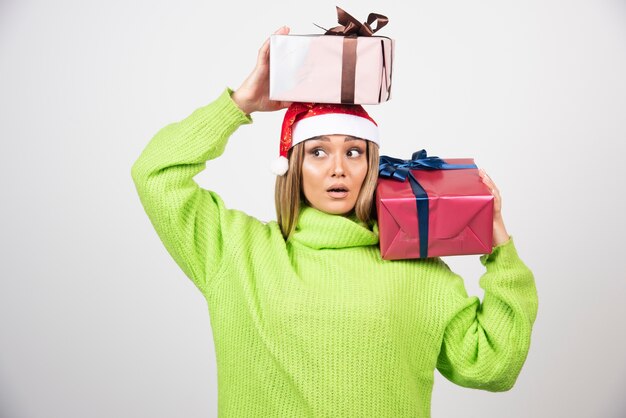 Jeune femme tenant des cadeaux de Noël festifs.