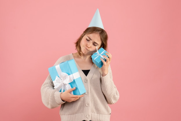 jeune femme tenant des cadeaux de Noël sur rose