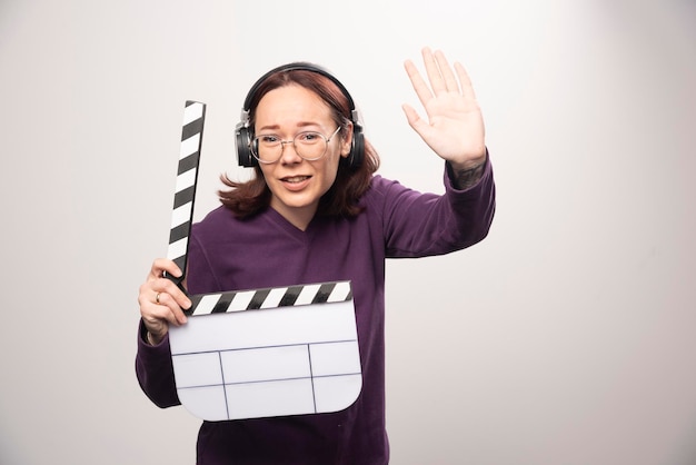 Jeune femme tenant une cassette de cinéma sur fond blanc. photo de haute qualité