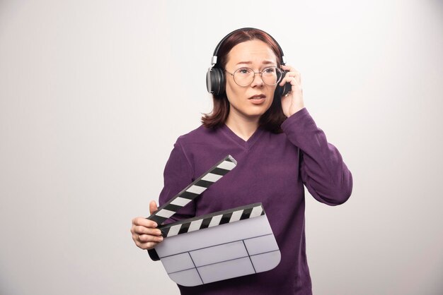 Jeune femme tenant une cassette de cinéma sur fond blanc. photo de haute qualité