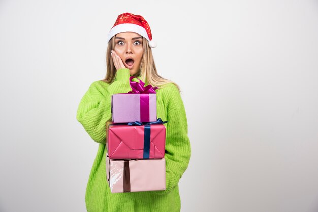 Jeune femme tenant dans les mains des cadeaux de Noël festifs.