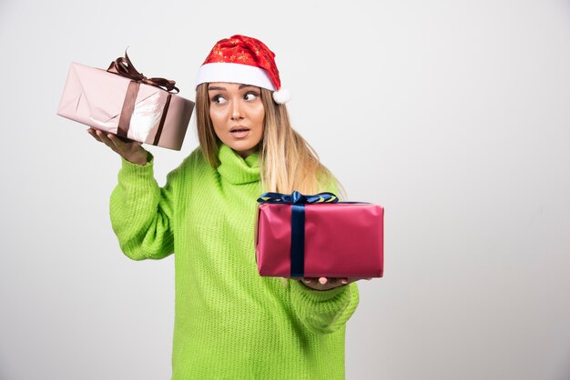Jeune femme tenant dans les mains des cadeaux de Noël festifs.
