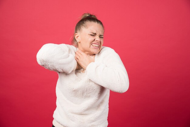 Une jeune femme tenant la gorge et souffrant de douleur