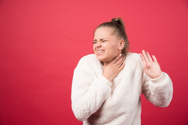 Photo gratuite une jeune femme tenant la gorge et souffrant de douleur