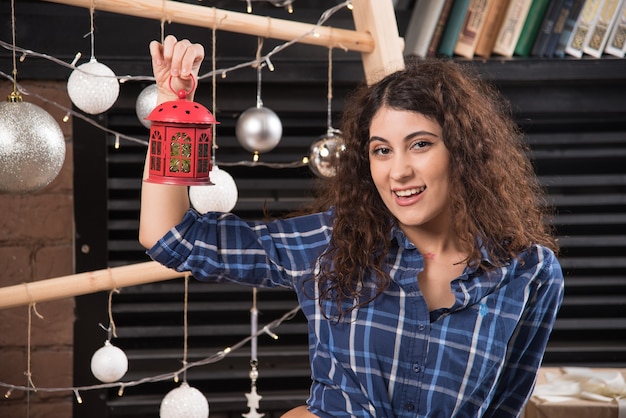 Jeune femme tenant une lampe de Noël rouge