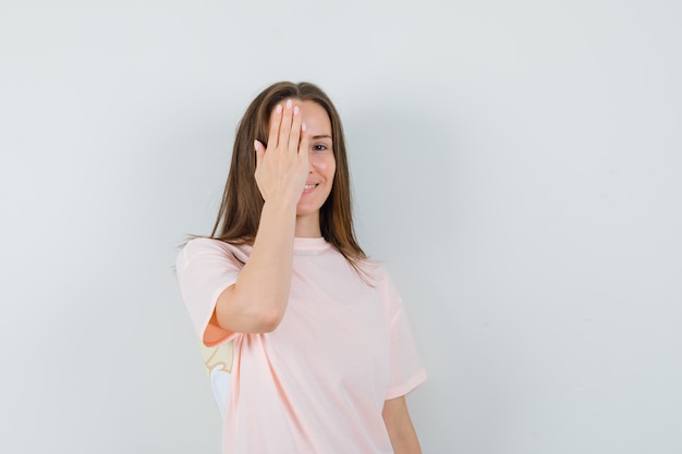 Jeune femme tenant la main sur les yeux en t-shirt rose et à la joyeuse