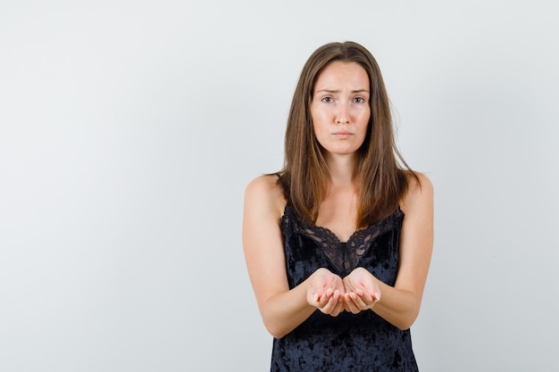 Jeune femme tenant les mains en coupe en maillot noir et à l'humble