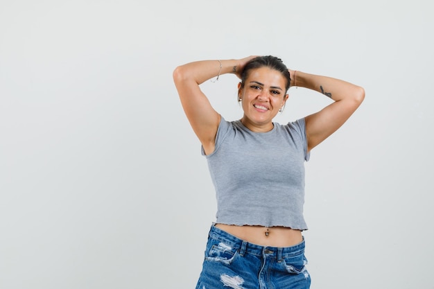 Jeune femme tenant les mains derrière la tête en t-shirt, short et à la belle