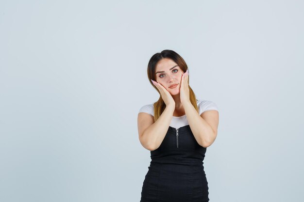 Jeune femme tenant les mains sur les joues et à la grave