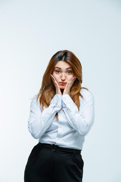 Jeune femme tenant les mains sur les joues et à la mignonne