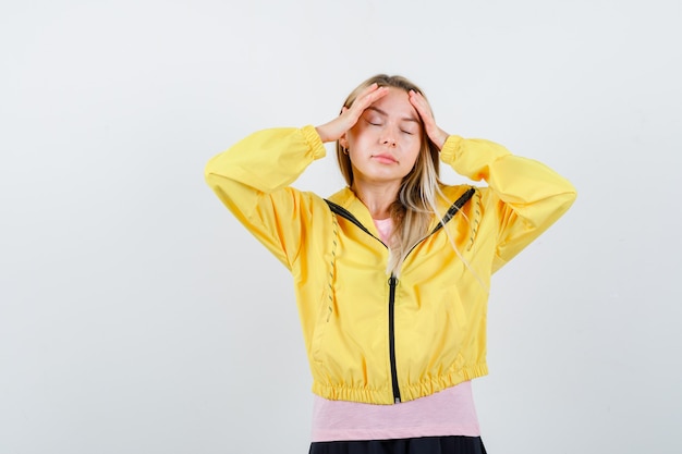 Jeune femme tenant les mains sur la tête en t-shirt, veste et à épuisé