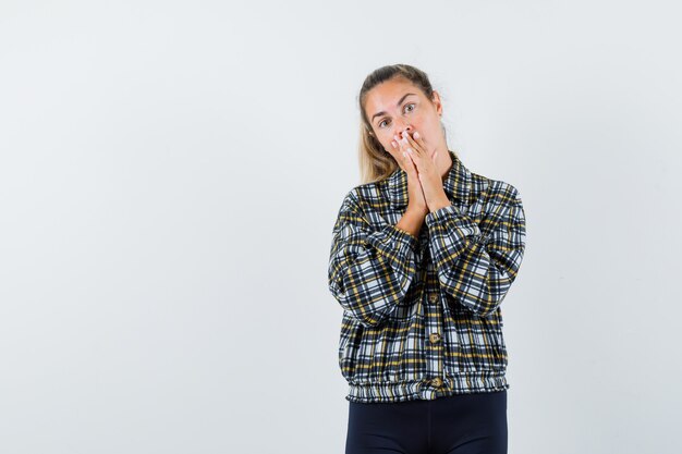 Jeune femme tenant par la main en signe de prière en chemise, short et à la recherche d'espoir, vue de face.