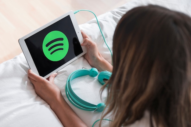 Jeune femme tenant une tablette avec l&#39;application Spotify