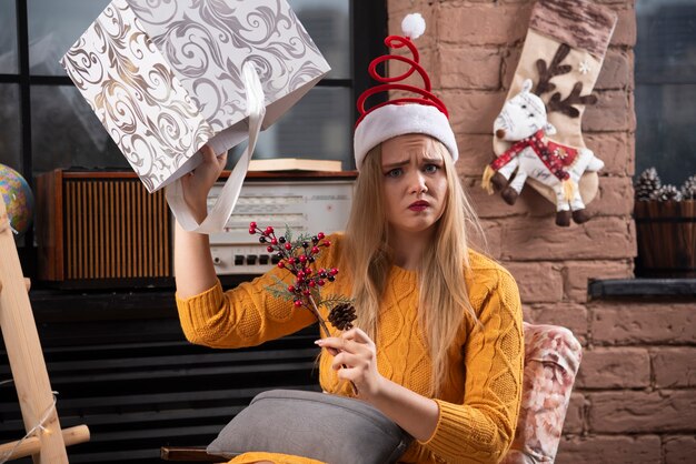 Jeune femme tenant tristement la boîte de Noël.